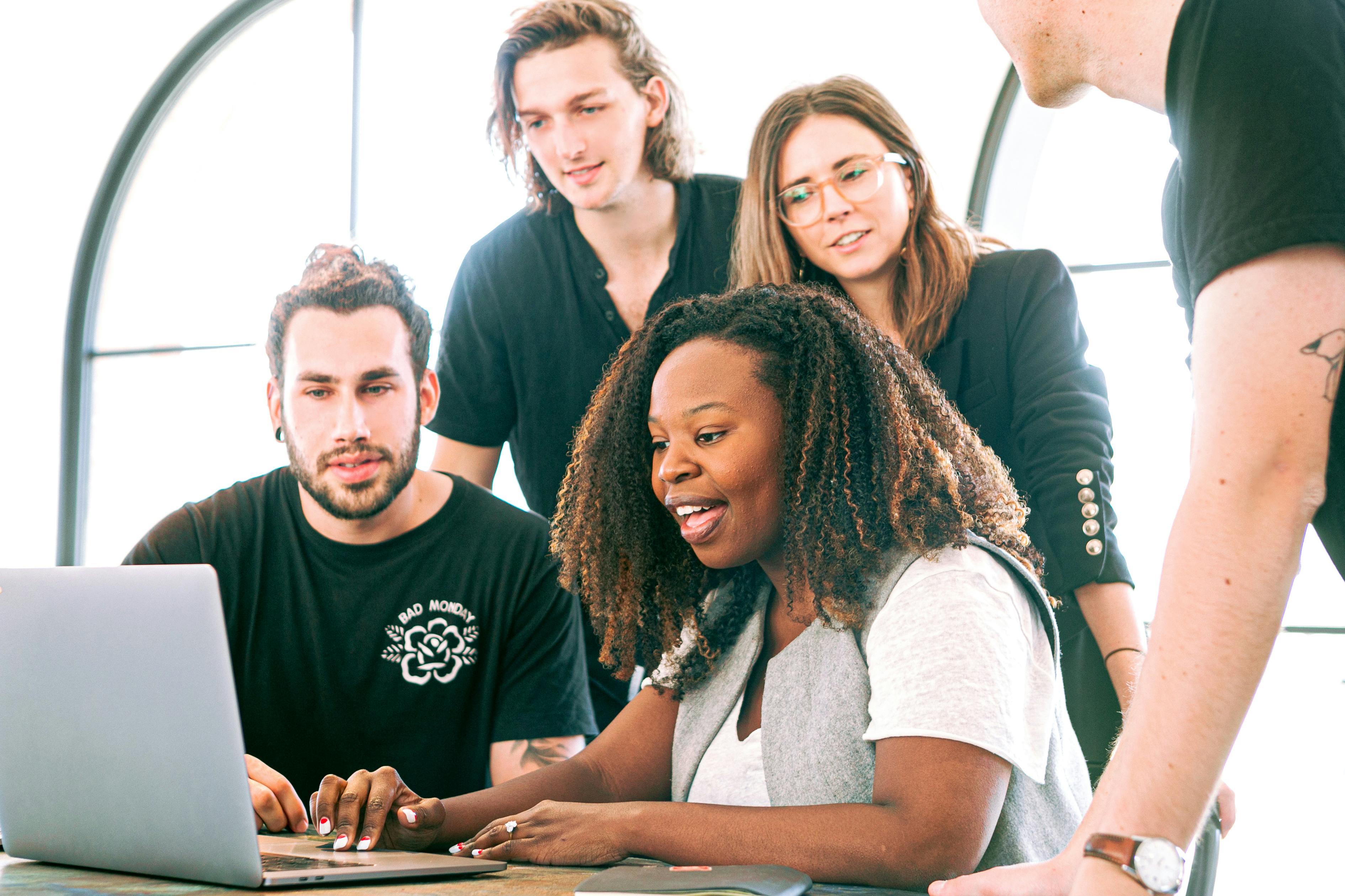 Group of employees looking at a computer together